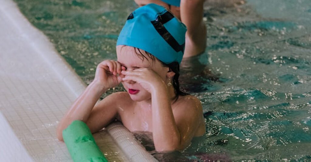 Un enfant dans une piscine en train d'apprendre à nager