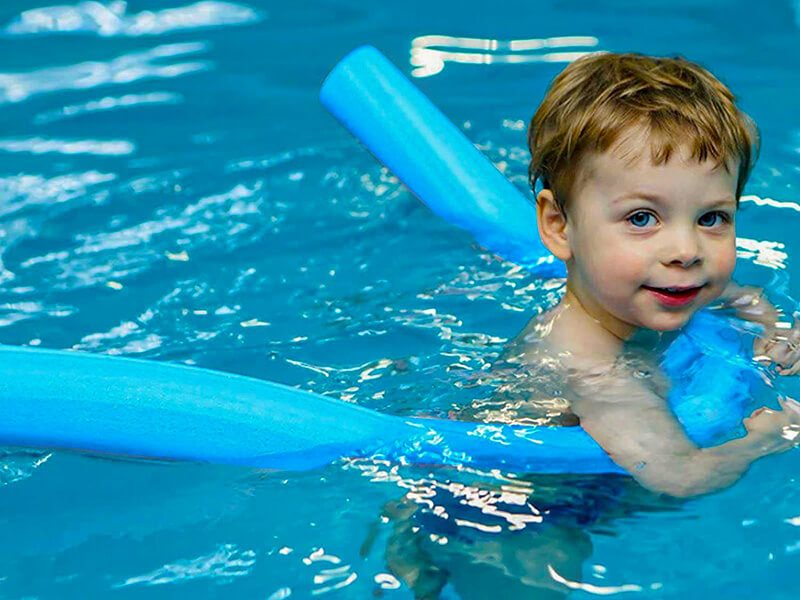 Un garçon dans une piscine avec une frite de natation