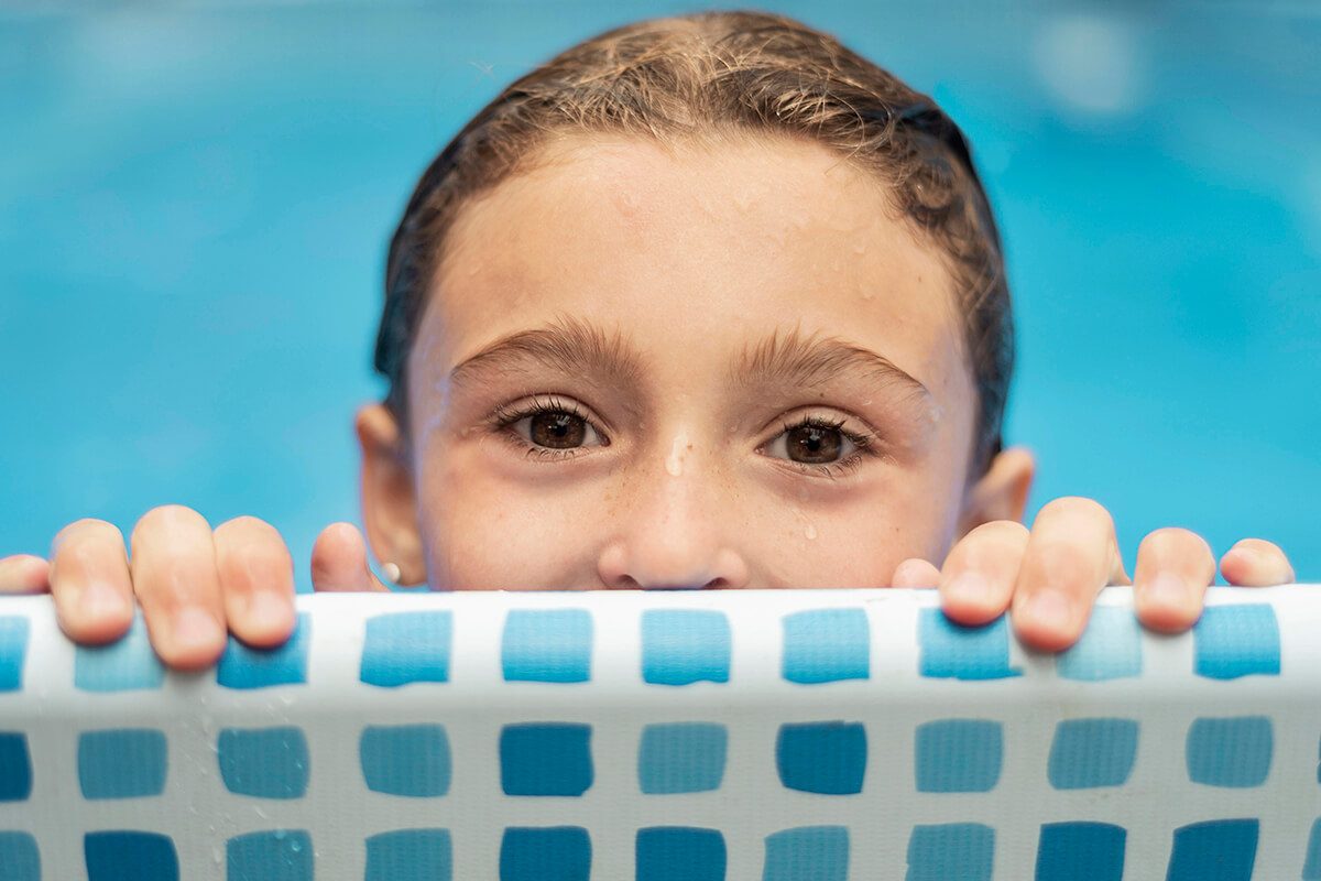 Une petite fille qui se tient au bord d'une piscine