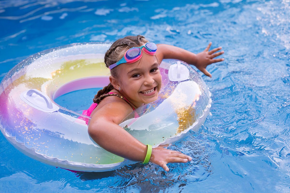 Une enfant qui joue avec une bouée dans une piscine