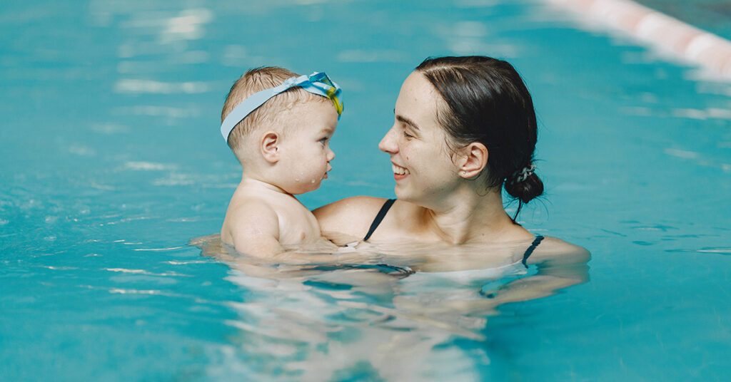 Une maman avec son bébé dans le bassin d'une piscine