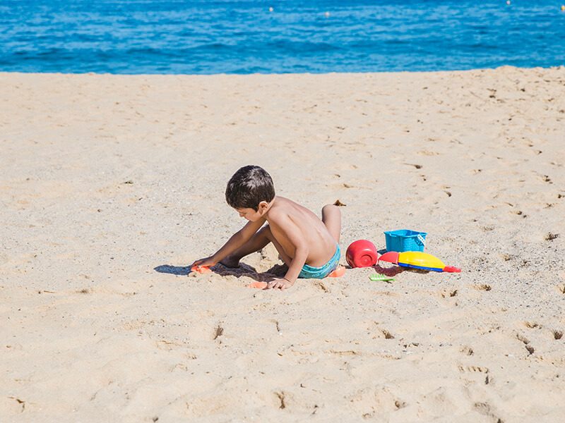 Un bébé qui joue sur le sable à la plage