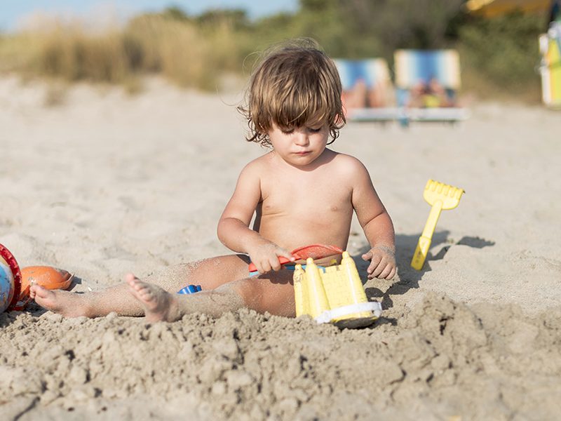 Un bébé qui joue sur la plage avec une pelle et un seau