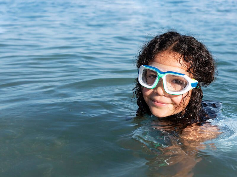 Une petite fille avec son masque de snorkeling dans l'eau