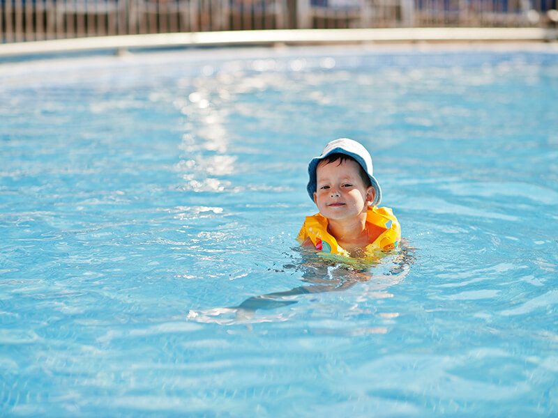 Un enfant avec un gilet de natation dans une piscine