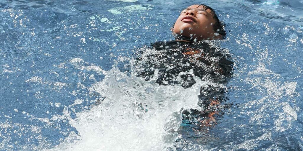 Bébé piscine chlore : un enfant qui nage sur le dos dans une piscine