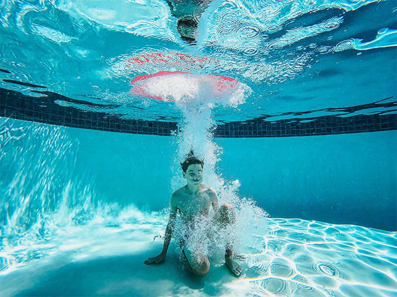 Un enfant dans l'eau au fond d'une piscine