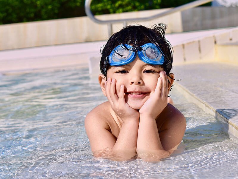 Un bébé au bord de l'eau dans une piscine