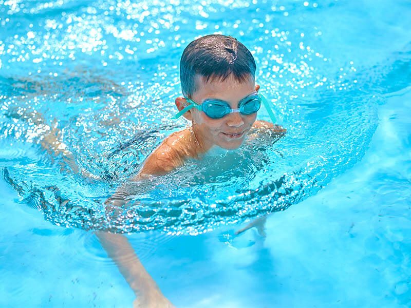 Un enfant dans le bassin d'une piscine 
