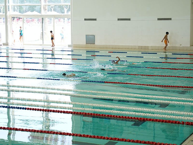 Une piscine municipale avec des enfants qui nagent