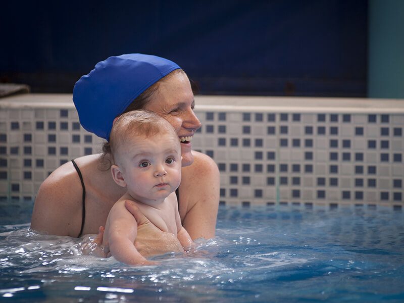 Une maman avec son bébé dans l'eau d'une piscine