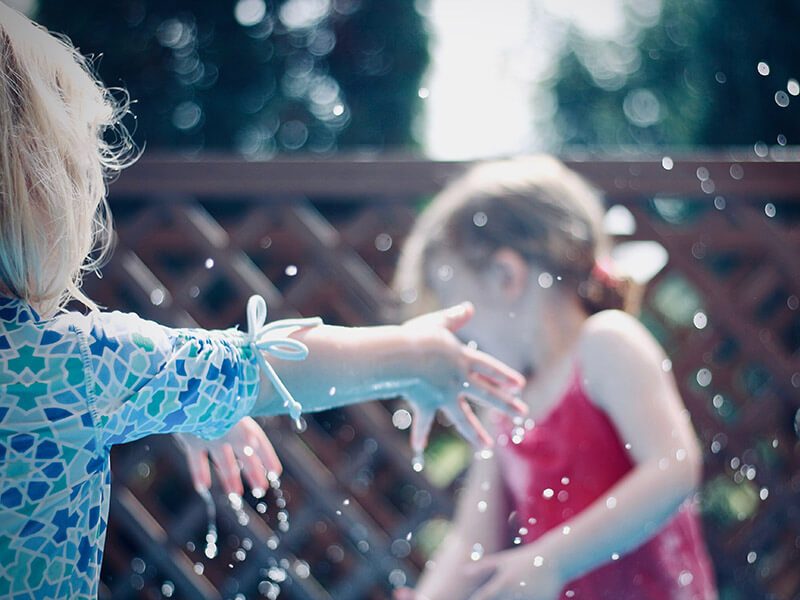 Deux enfants qui jouent avec l'eau