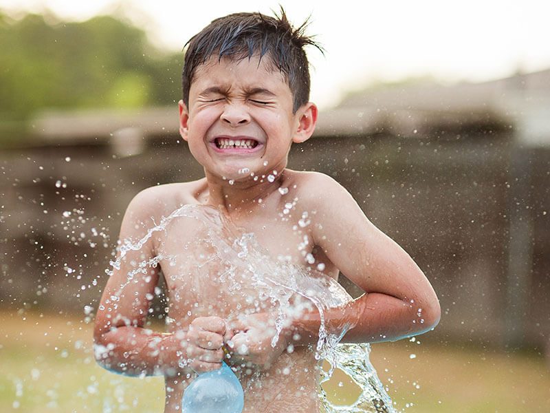 Un enfant qui s'amuse avec un ballon rempli d'eau dans une piscine