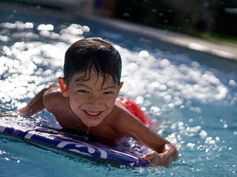 Un enfant qui s'amuse dans une piscine avec un body board