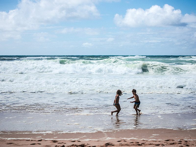 Deux enfants qui jouent au bord de l'eau à la plage