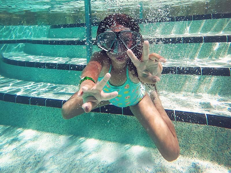 Une petite fille sous l'eau avec un masque de plongée