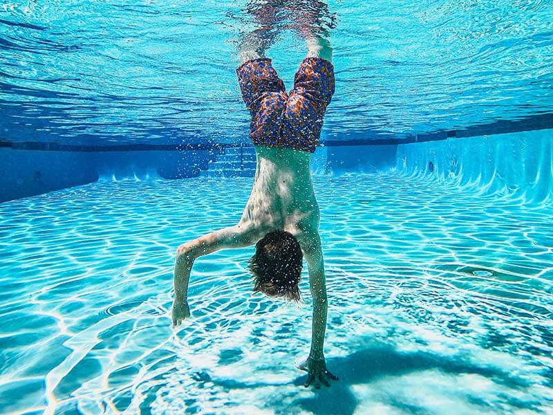 Un enfant qui touche le fond de la piscine avec sa main