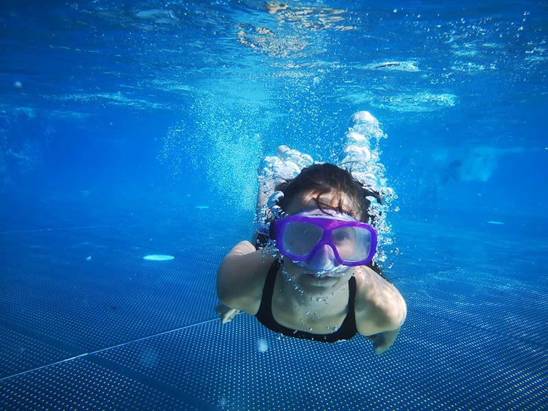 Une fille qui nage sous l'eau avec un masque de plongée