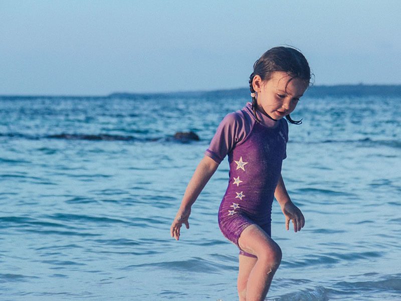 Une petite fille qui joue au bord de la plage