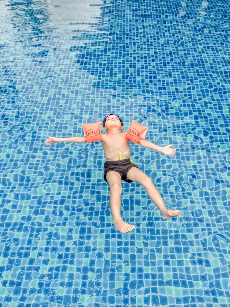 Nager sur le dos : enfant sur le dos portant des brassards